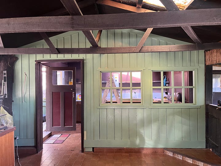 A wall with two interior windows and some trim being prepared