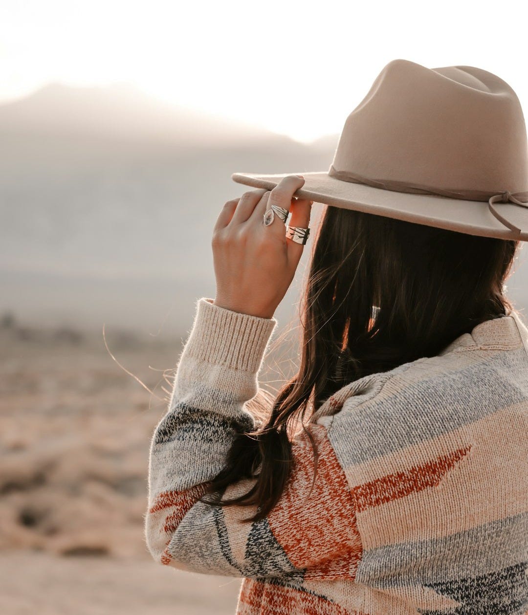 Woman wearing hat looks at distant mountains Woman wearing hat looks at distant mountains