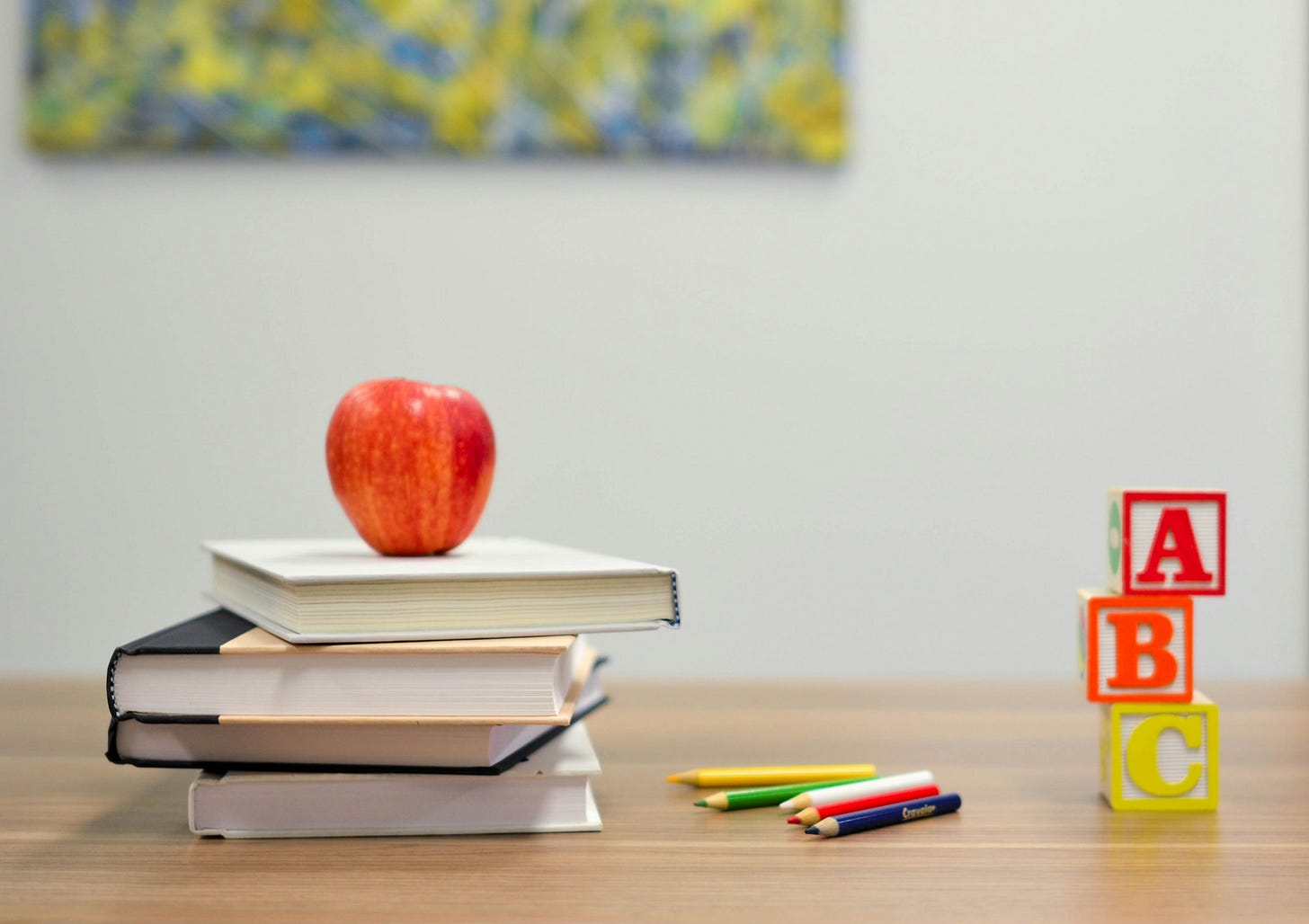 A desk with text books and an apple