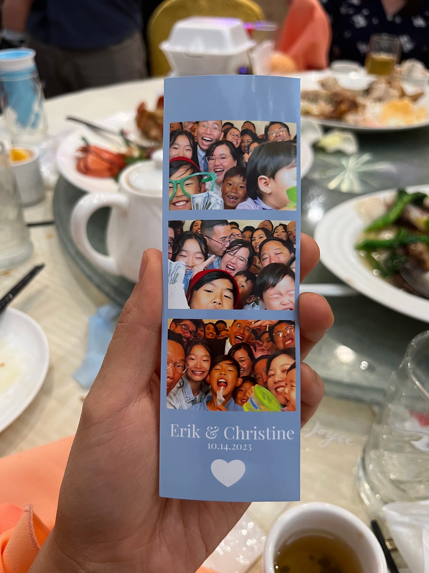 A hand holding a photobooth strip filled with lots of people.