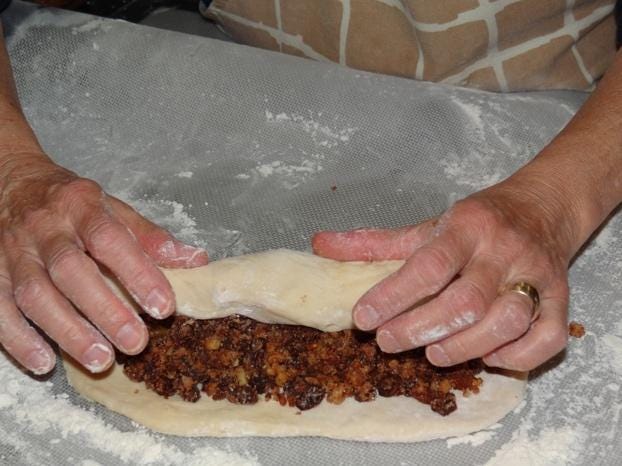A person making a pastry

Description automatically generated