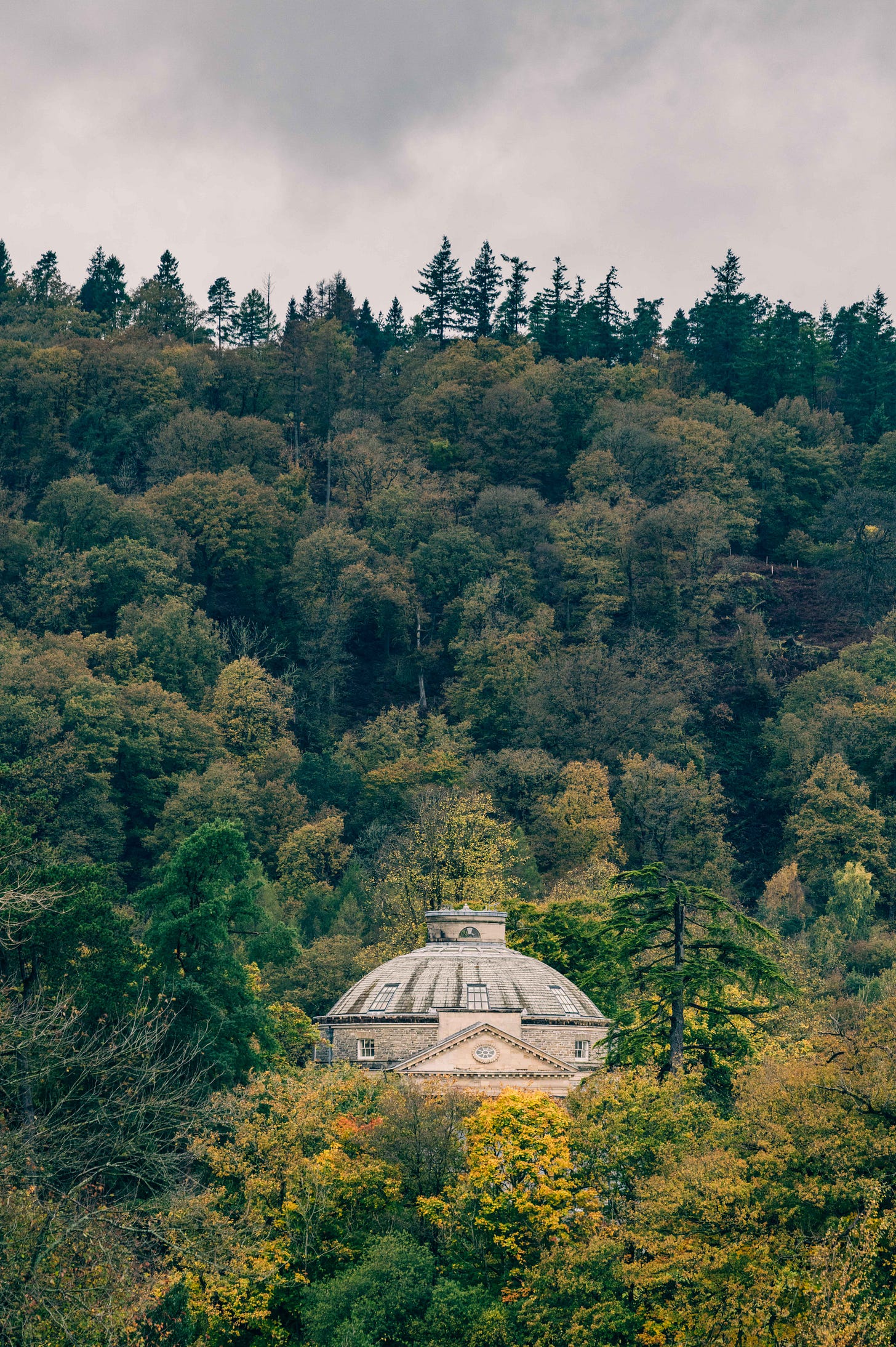 Historic domed building surrounded by dense autumn woodland in the Lake District, Cumbria, UK architecture and landscape scene. Historic domed building surrounded by dense autumn woodland in the Lake District, Cumbria, UK architecture and landscape scene.