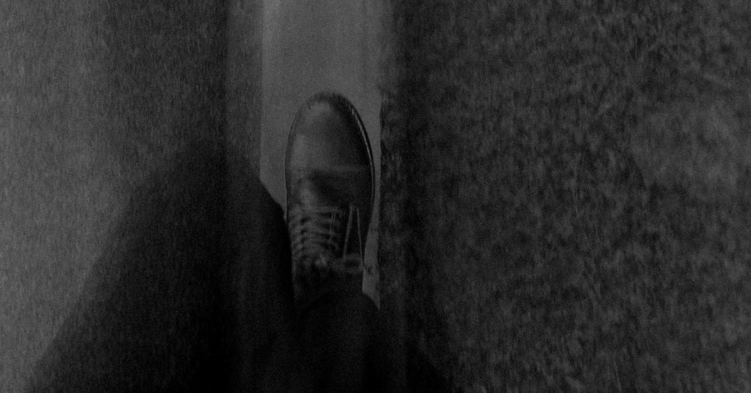a black and white photo of a person's shoes a black and white photo of a person's shoes
