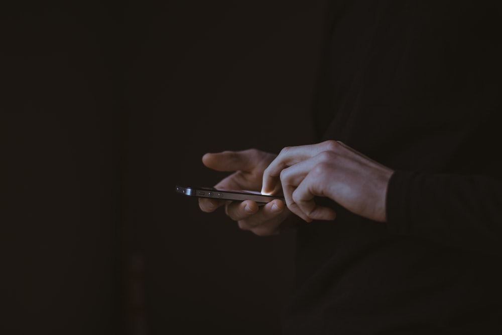 silhouette photo of person holding smartphone silhouette photo of person holding smartphone