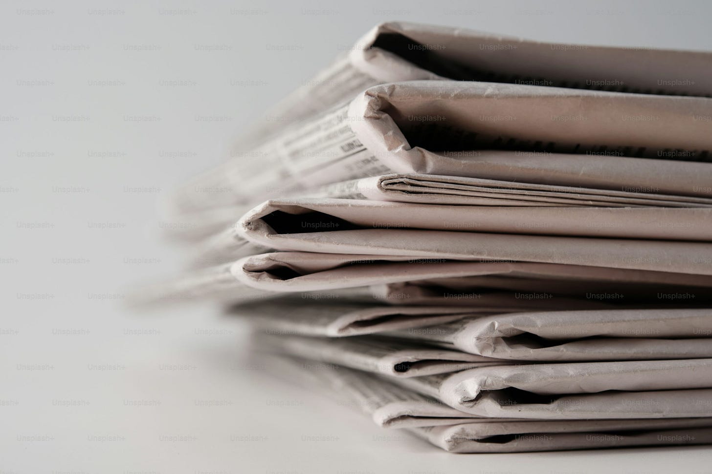 A stack of newspapers sitting on top of a table