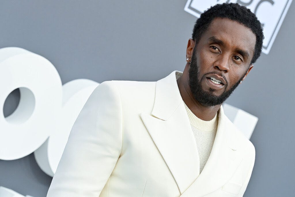 Sean Combs wearing a white suit jacket.