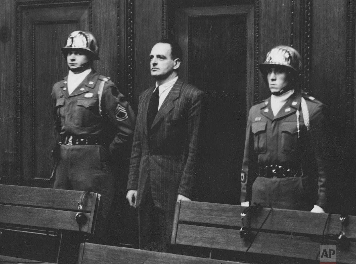 Dr. Edmund Veesenmeyer is sentenced to 20 years imprisonment, escorted by U.S. Army honor guards Sgt. Thomas H. Andress and Pfc. Jene R. Vaughan during the Nuremberg trials.
