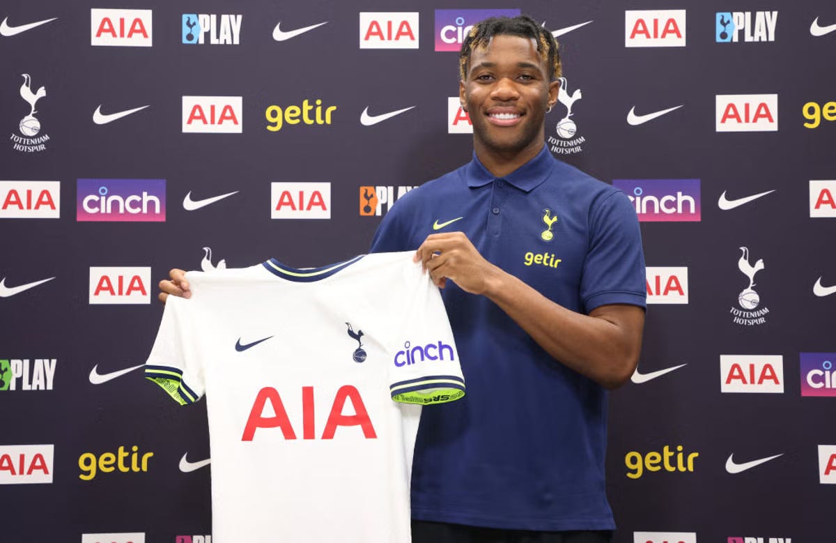 Tottenham Hotspur footballer Destiny Udogie holding up a Spurs shirt