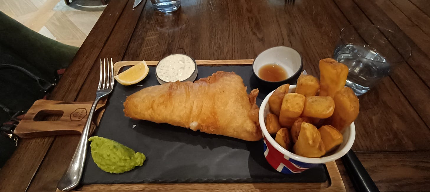 A platter of fish and chips with mushy peas