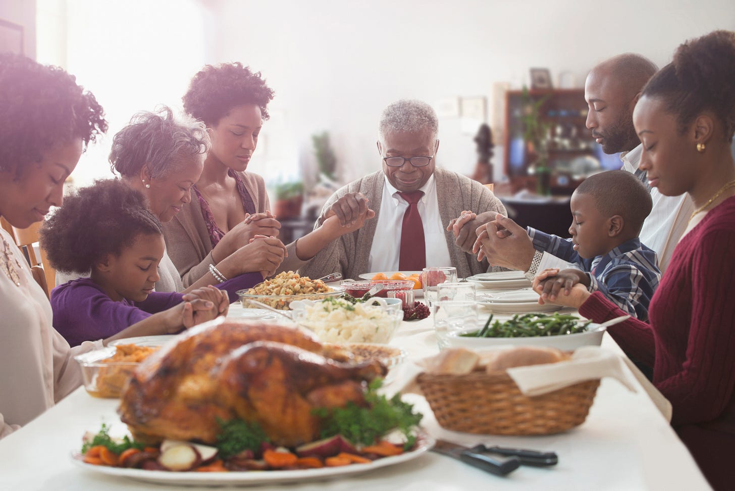 A family says grace around the Thanksgiving table. A family says grace around the Thanksgiving table.