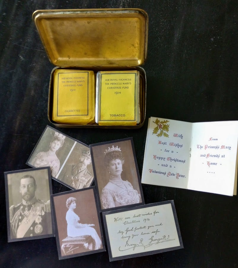 Open tin containing pack of pipe tobacco and a pack of cigarettes, along with paper contents Open tin containing pack of pipe tobacco and a pack of cigarettes, along with paper contents