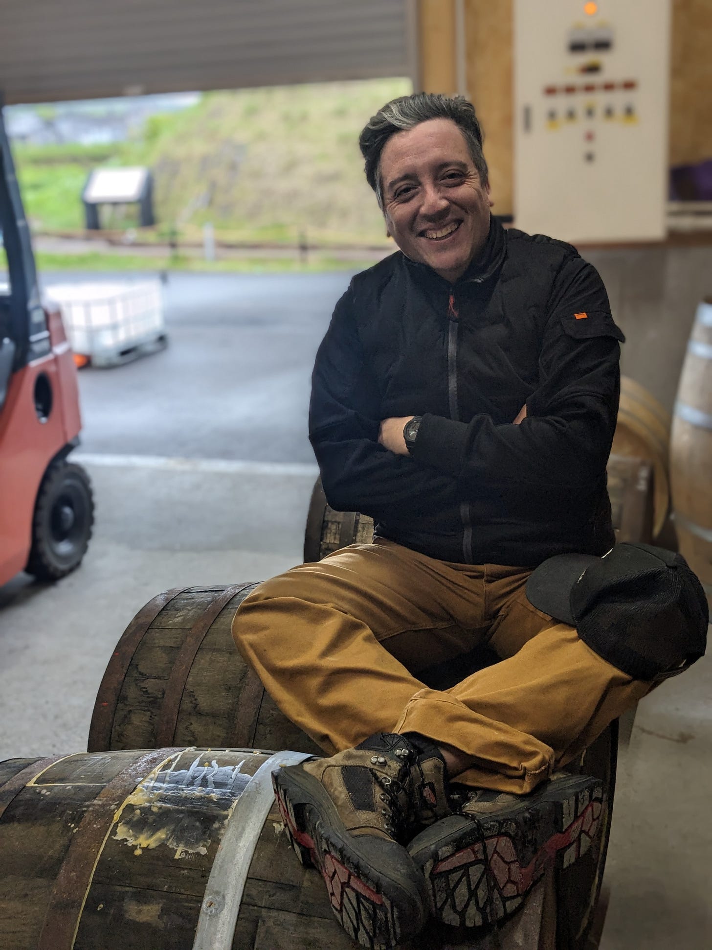 Head Distiller Javier sitting on whisky barrel during informal warehouse meeting at Rishiri distillery