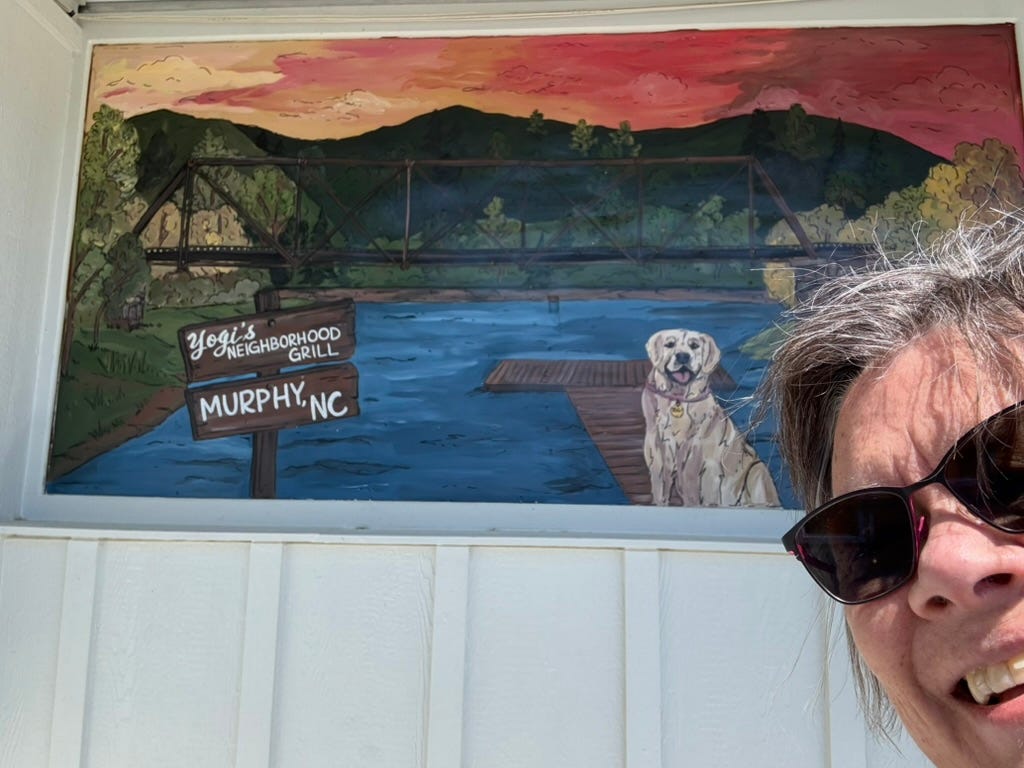woman in front of a sign for Yogi's Neighborhood Grill