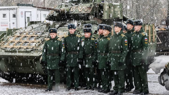 Russian servicemen near a U.S. M2 Bradley fighting vehicle captured in Ukraine.