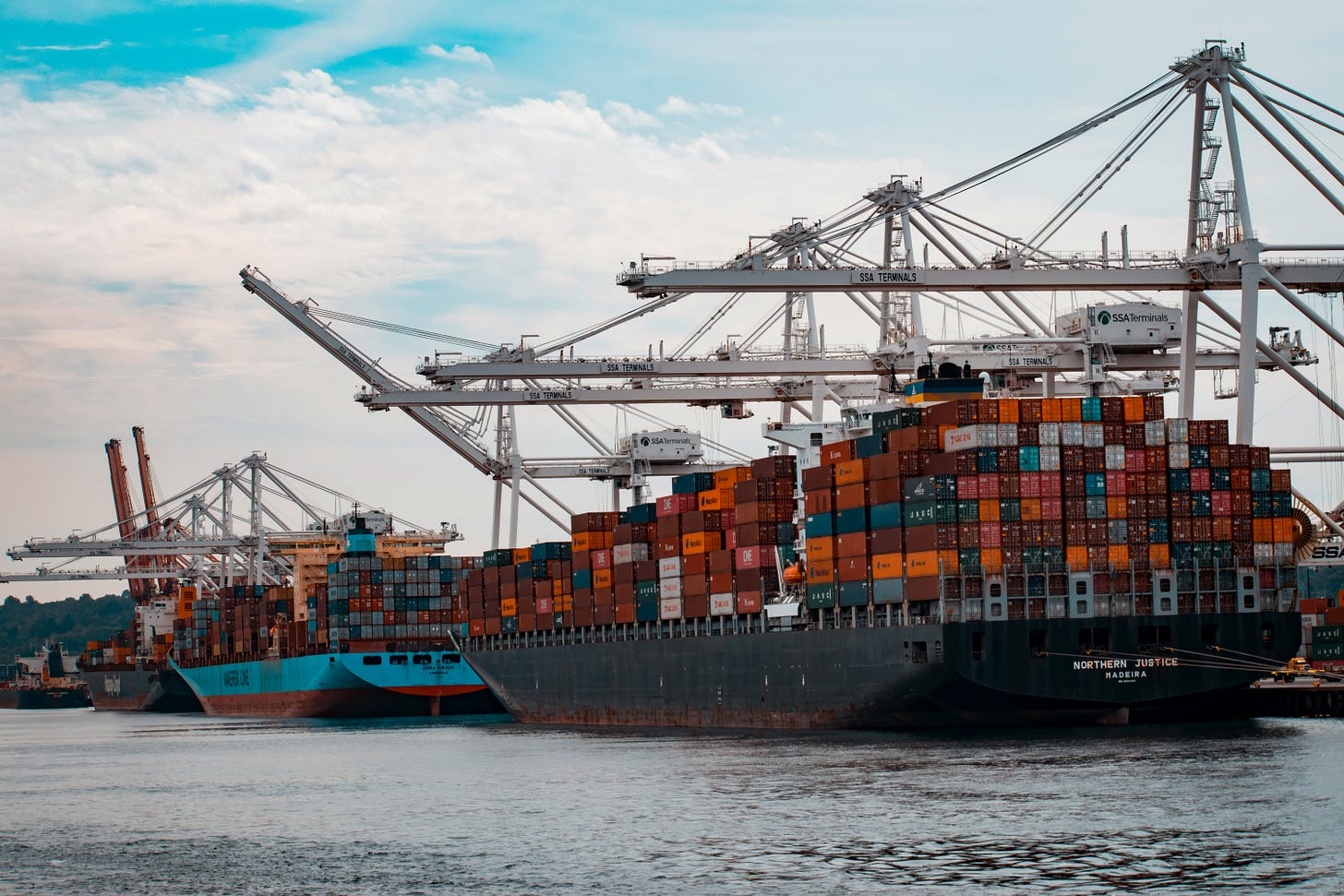 photo of container ships docked at a pier during the daytime