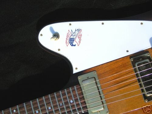 A close-up of a guitar with a sticker on it, showcasing a 1976 Gibson "Bicentennial" Firebird.