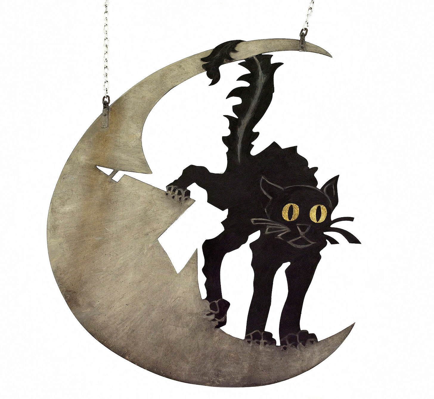 A black cat with its back arched and fur standing on end, cut from sheet metal and painted, crouches on a pale crescent moon with an angry face, against a night sky. A black cat with its back arched and fur standing on end, cut from sheet metal and painted, crouches on a pale crescent moon with an angry face, against a night sky.
