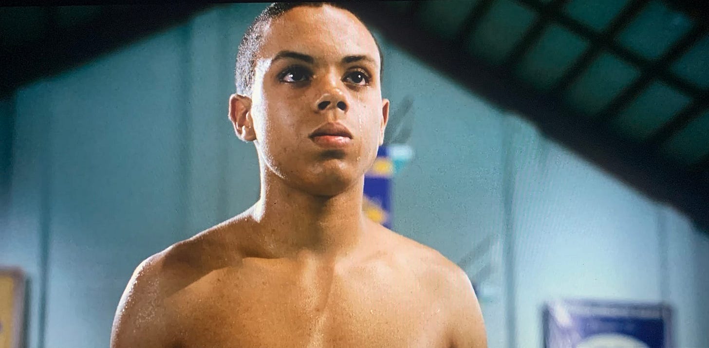 A young man without a shirt poses at the edge of a pool, embodying strength and readiness for the final relay.