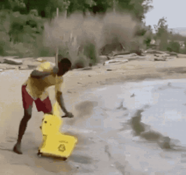 a man is cleaning the beach with a yellow mop bucket a man is cleaning the beach with a yellow mop bucket