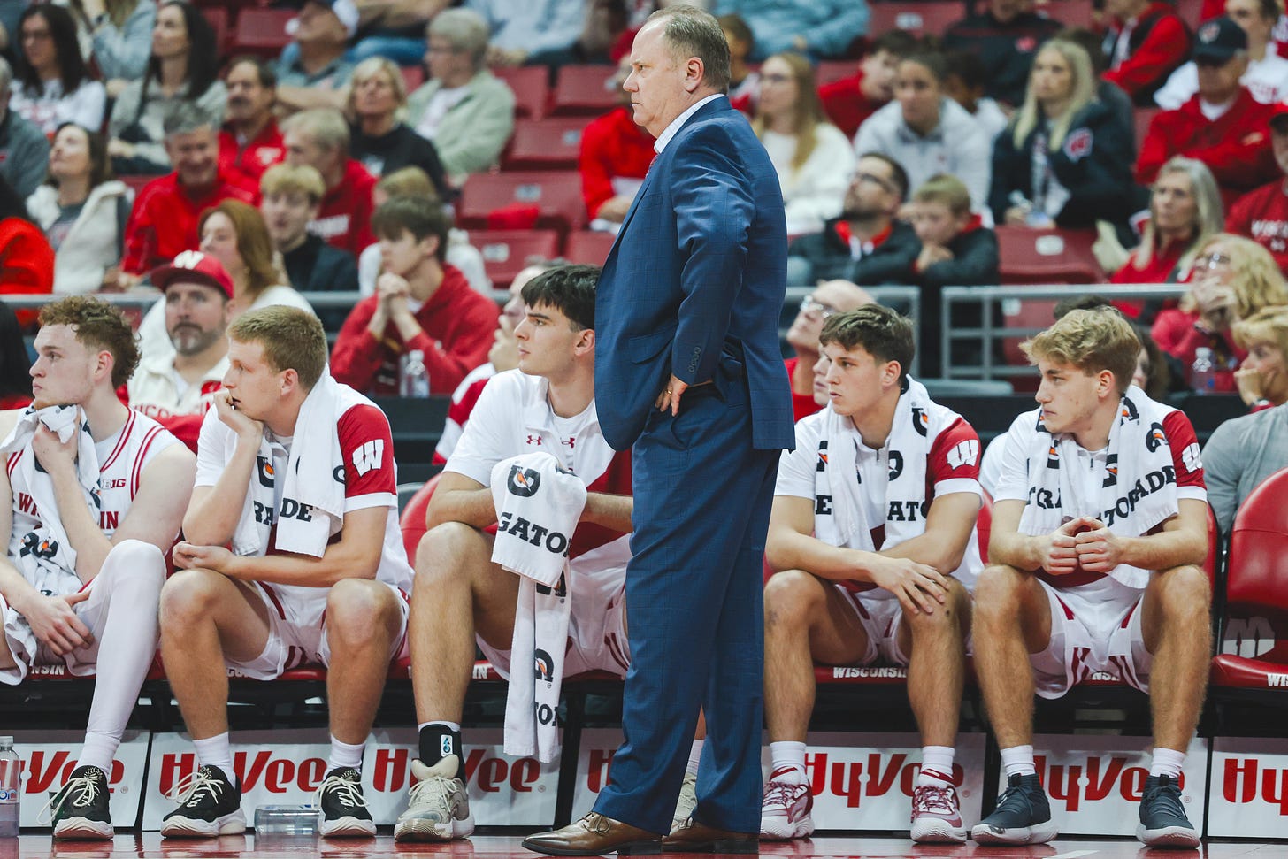 Wisconsin Badgers men's basketball head coach Greg Gard stands on his sideline in front of his team's bench during a game