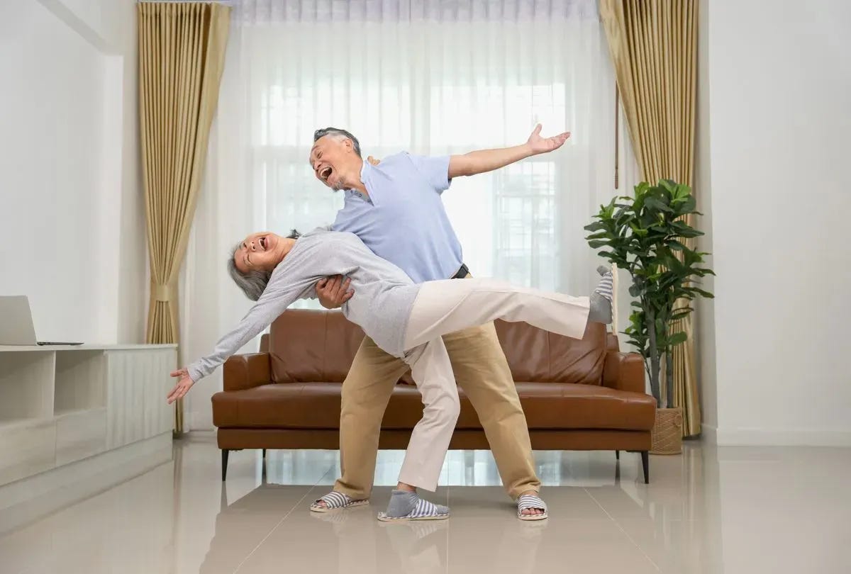 Happy couple dancing in their living room. Happy couple dancing in their living room.
