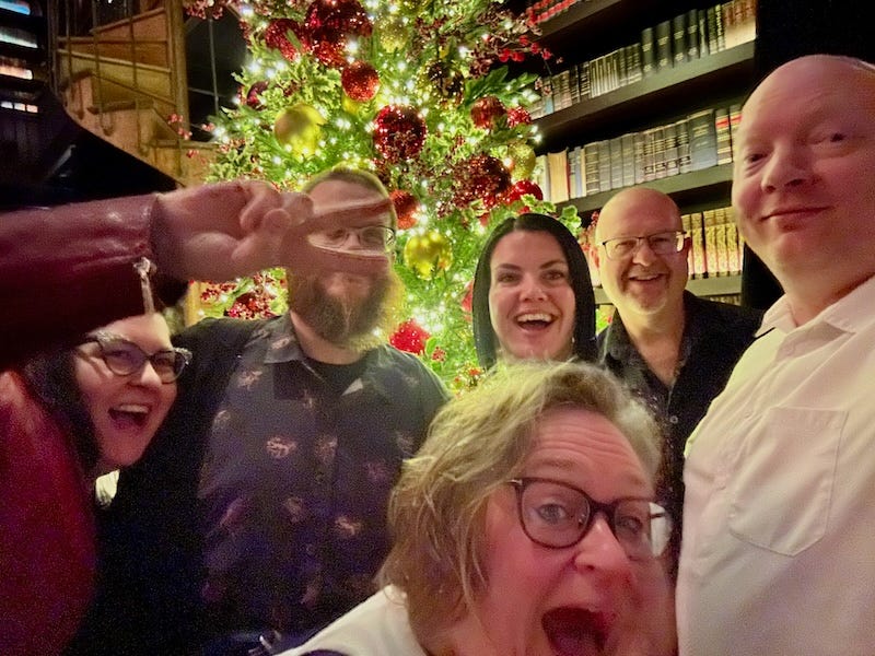 A group of people standing in front of a christmas tree