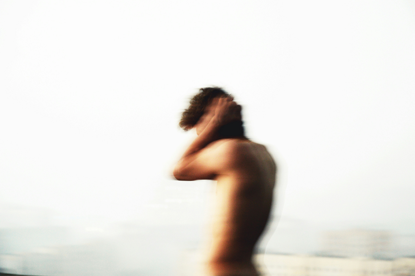 a blurry image of a man holding his head