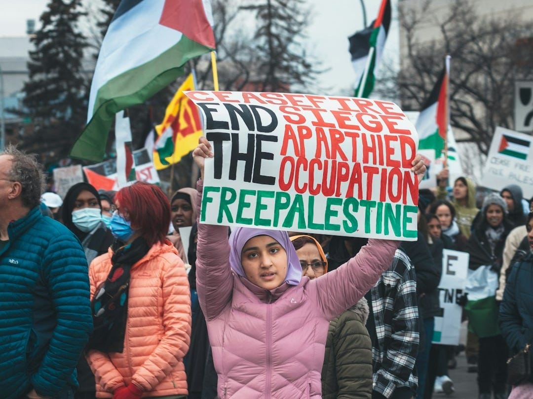 a woman holding a sign that reads free palestine