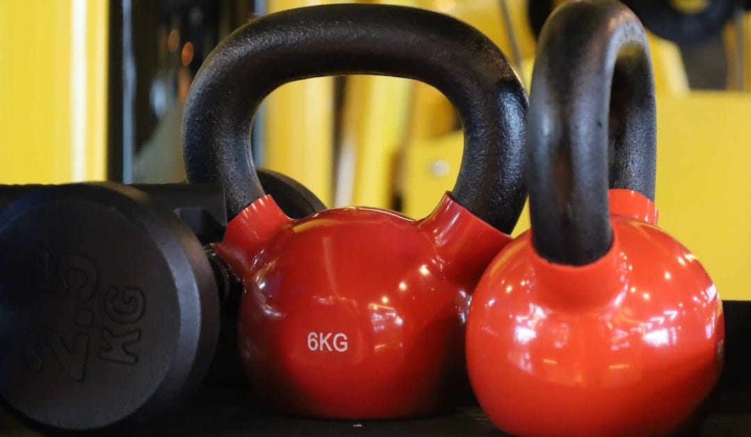 a couple of red kettles sitting on top of a shelf a couple of red kettles sitting on top of a shelf