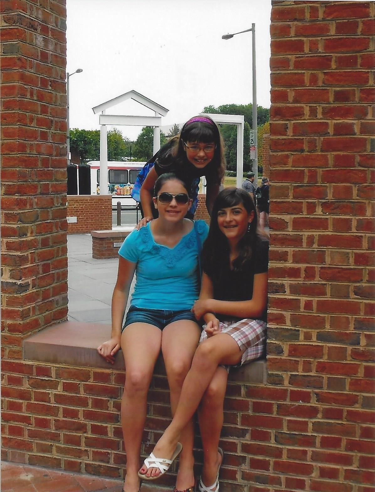 Three girls posed in a brick window well at the President's House museum in Philadelphia