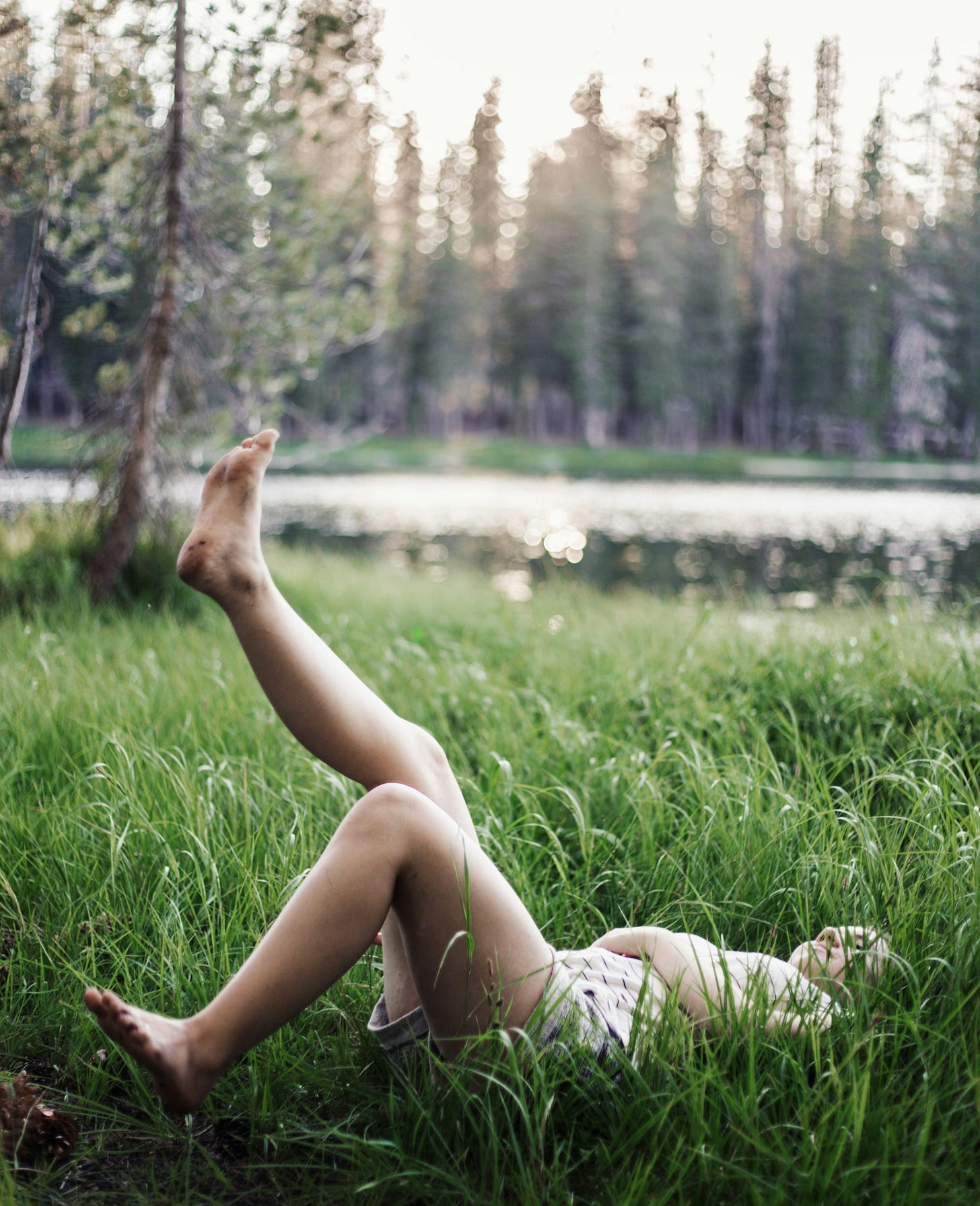 girl laying on green grass field