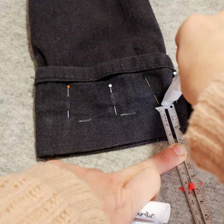 adding the seam allowance with a measuring gauge on pants