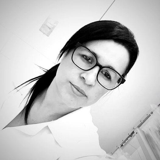 May be an image of 1 person, smiling, eyeglasses and hospital