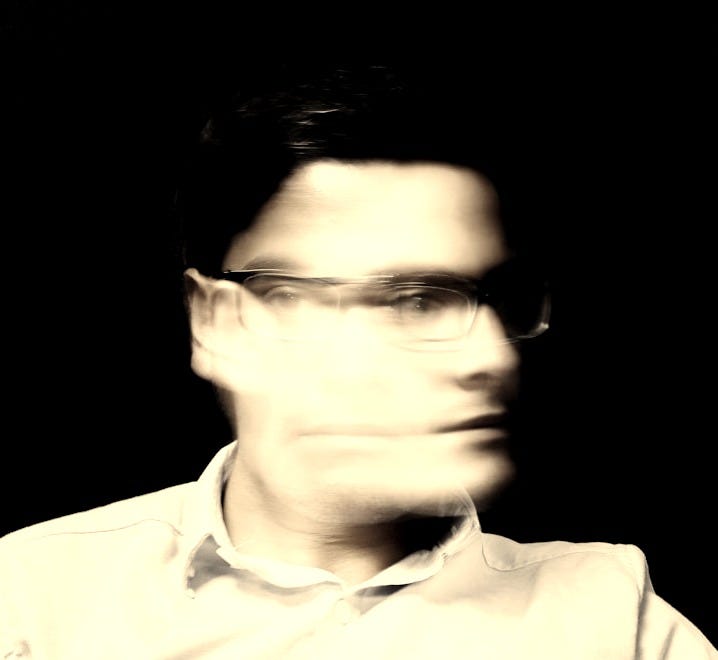 man wearing white button-up collared top and black framed eyeglasses