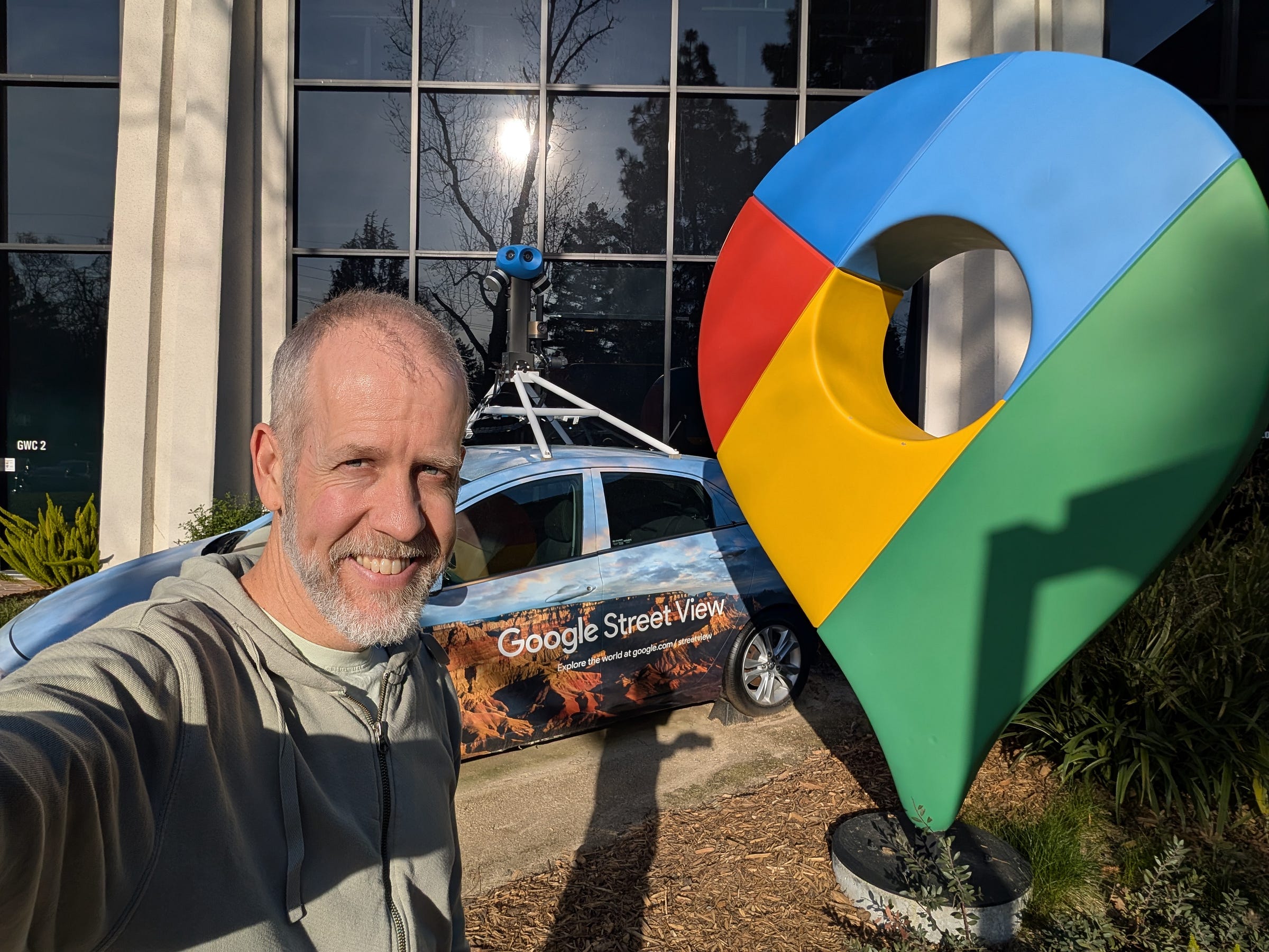 Brian standing in front of the Google Street View Car at the GWC office in Mountain View, CA with the huge Google Maps pin sculpture next to it.