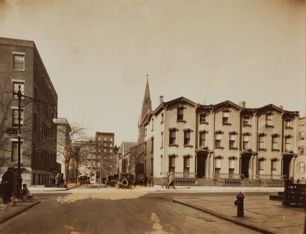 A black-and-white photo shows a row of houses in Brooklyn in 1925.