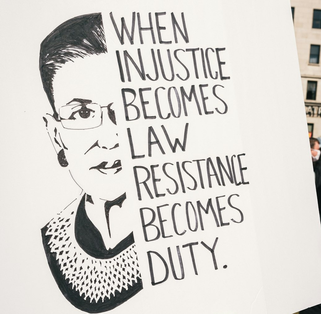 a person holding a sign that says when justice becomes law, resistance becomes duty