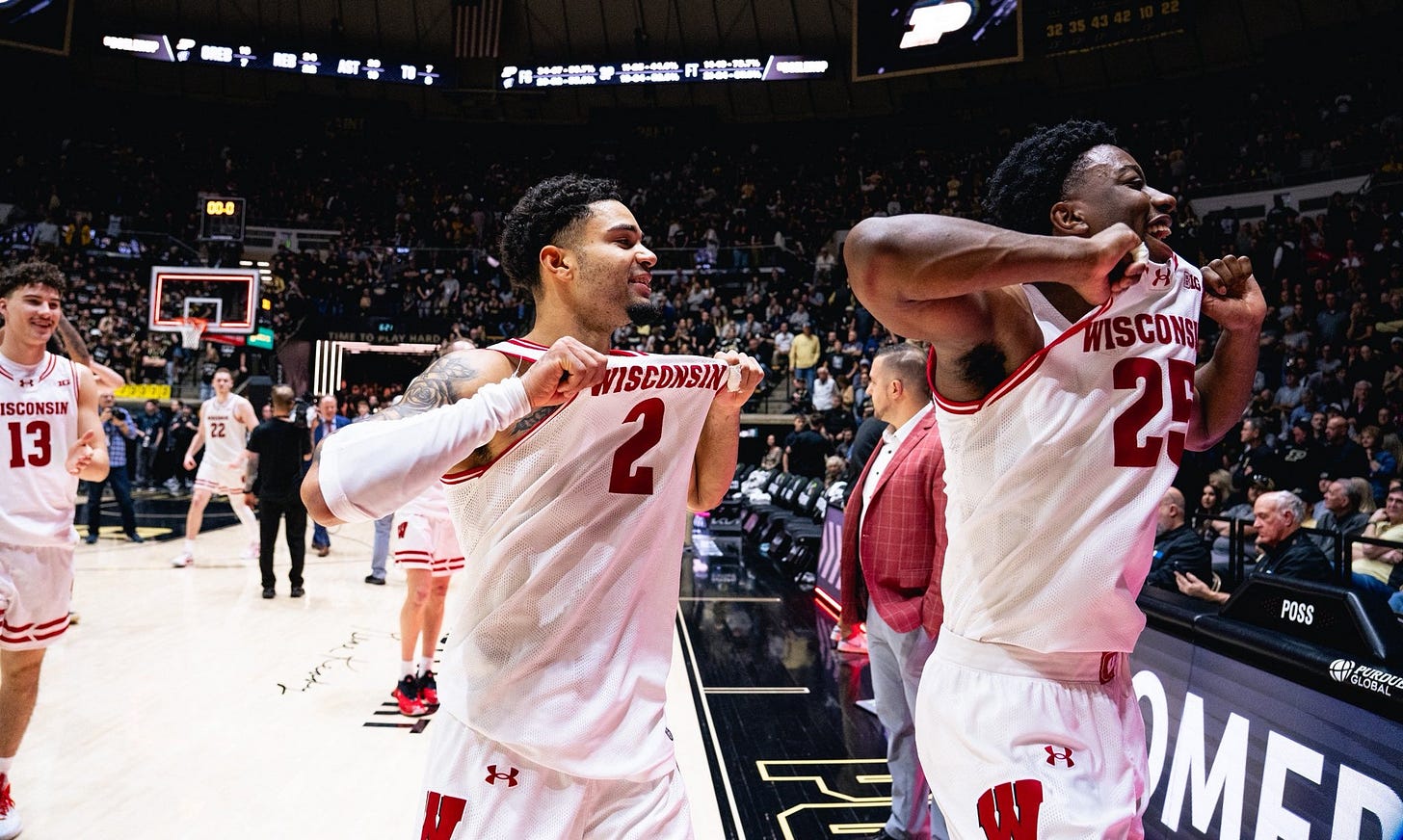 Wisconsin Badgers guards Nick Boyd and John Blackwell gesture toward the name on the front of their jerseys while celebrating in front of Purdue fans at Mackey Arena. Photo credit: UW Athletics.