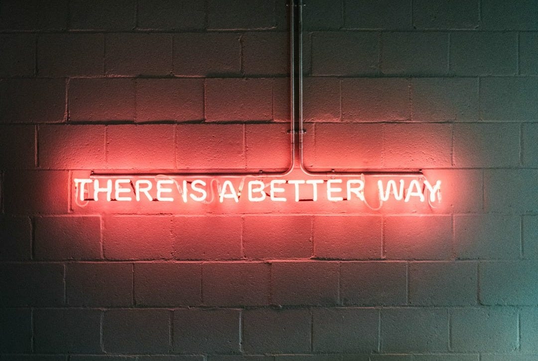 a brick wall with a neon sign that says there is a better way