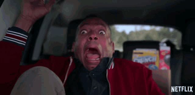 a man in a car with a crunch box in the back seat a man in a car with a crunch box in the back seat