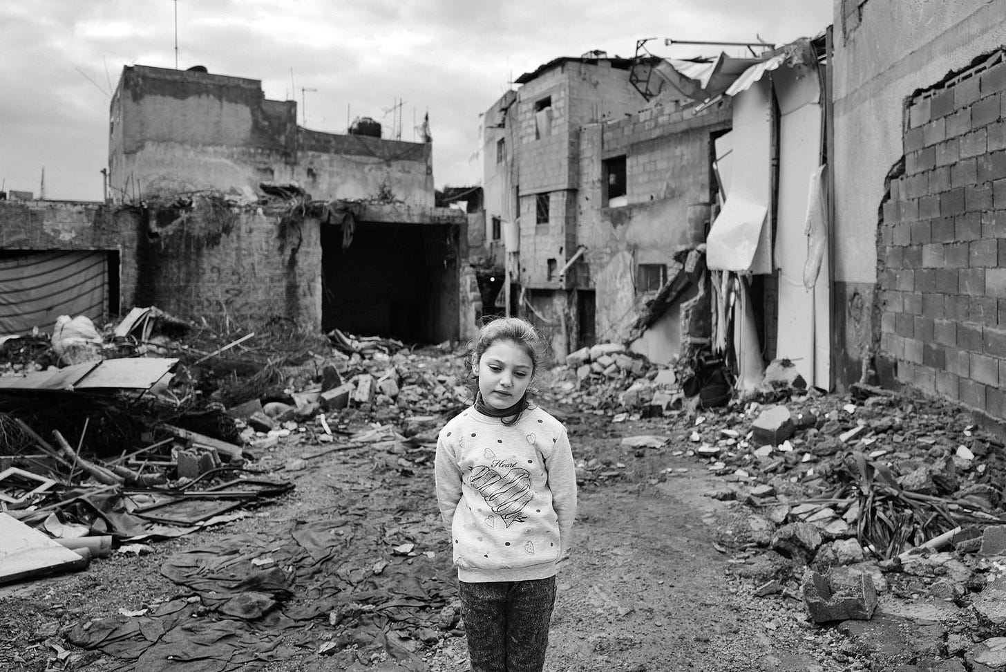 A girl standing in rubble.