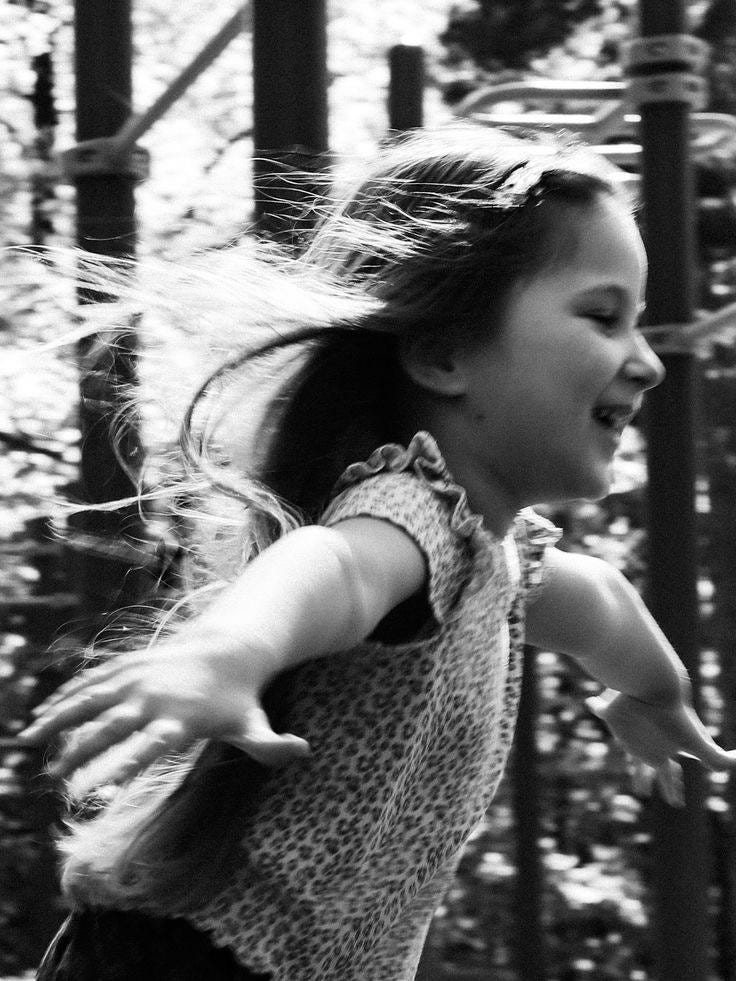 May be a black-and-white image of child, dancing and smiling