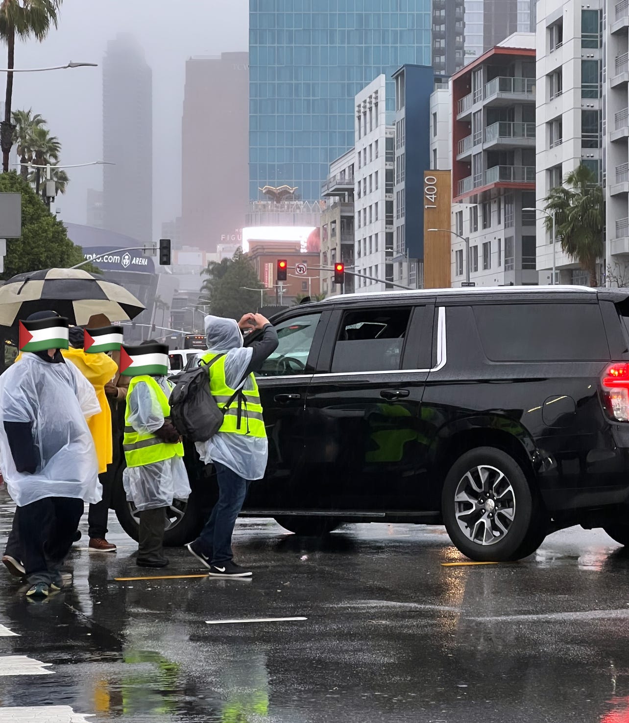 Protesters stand in front of a Black SUV as it attempts to past them to gain entrance into the ceremony.