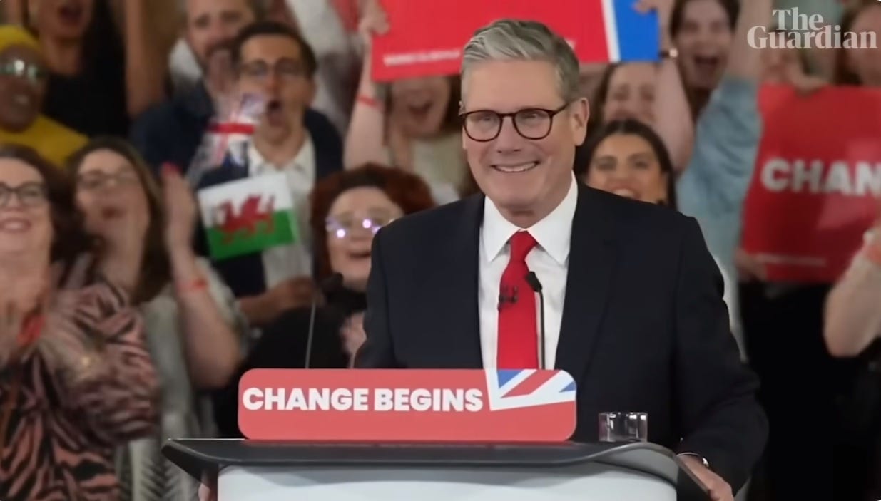 video screenshot of a smiling Labour Party leader Keir Starmer at a victory rally, speaking at a lectern holding a sign with the slogan 'Change Begins' video screenshot of a smiling Labour Party leader Keir Starmer at a victory rally, speaking at a lectern holding a sign with the slogan 'Change Begins'