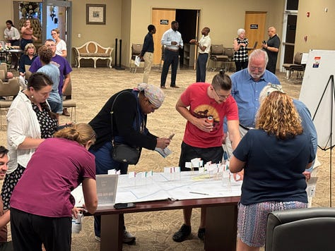 Photos of attendees at the 7-14-25 Powder Springs' Livable Centers Initiative (LCI) Plan Kick-off Meeting, with attendees submitting on sticky notes or other items ideas for the City of Powder Springs.