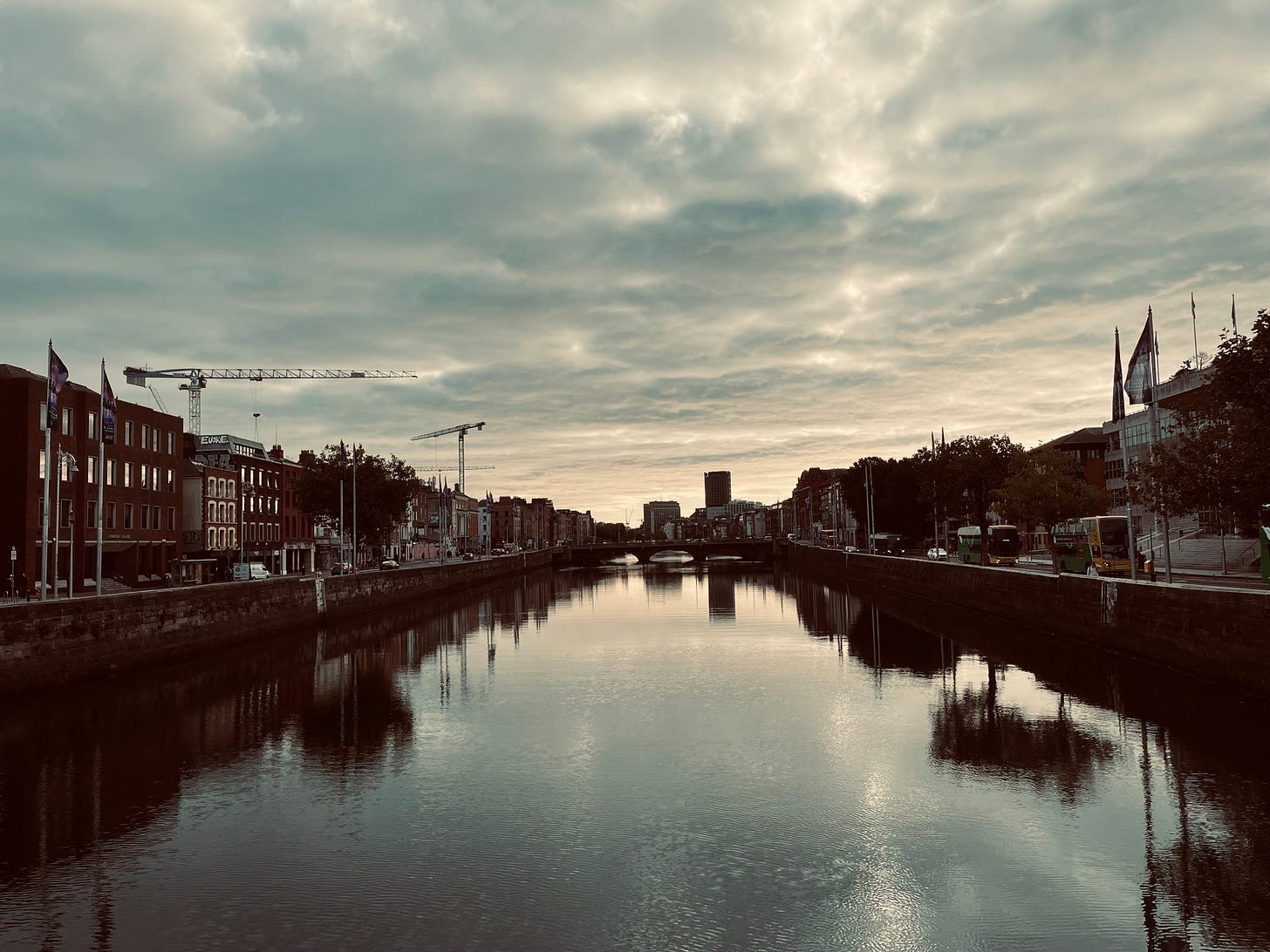 A body of water with buildings and a crane

Description automatically generated