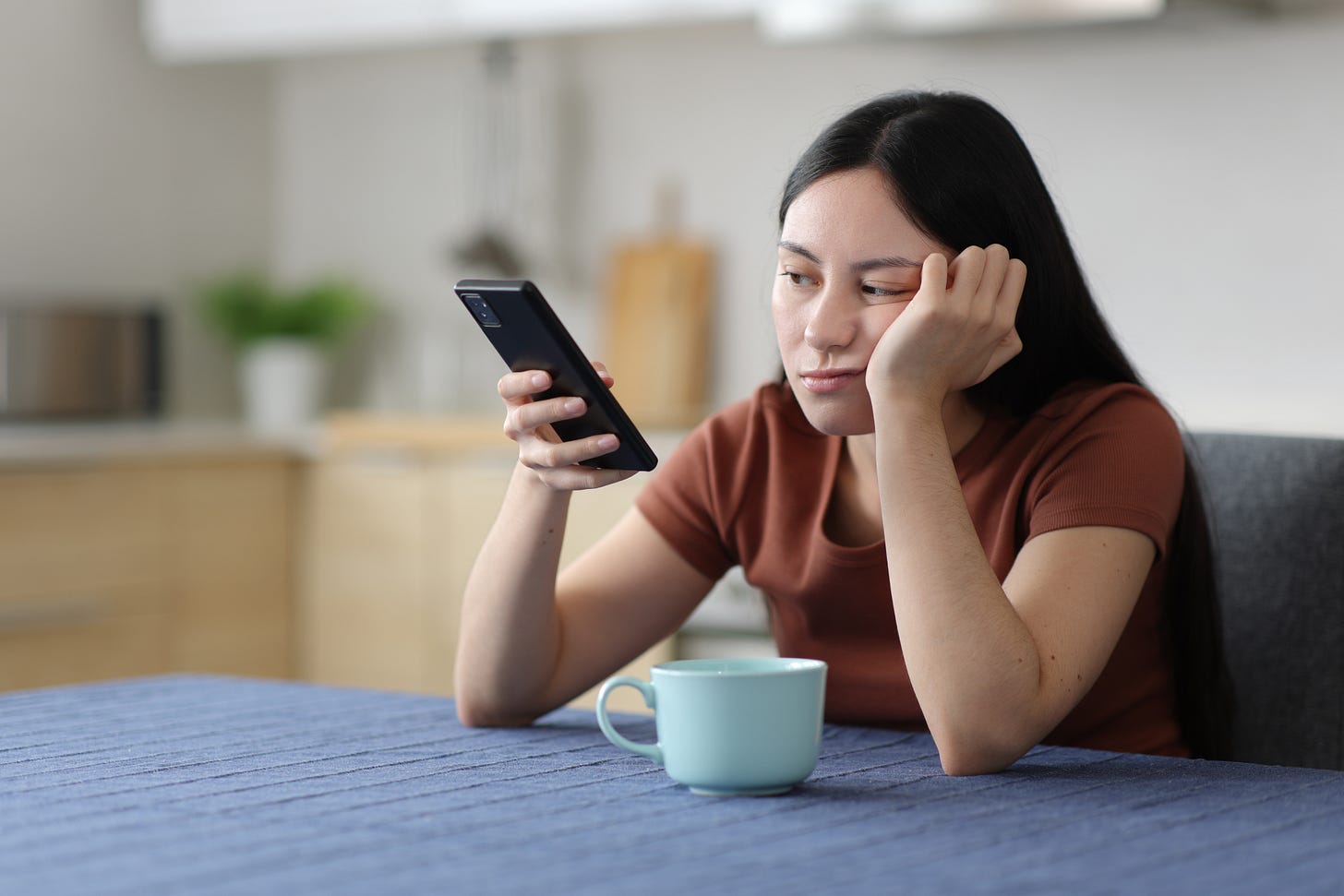 Bored woman waits for a message on her smartphone