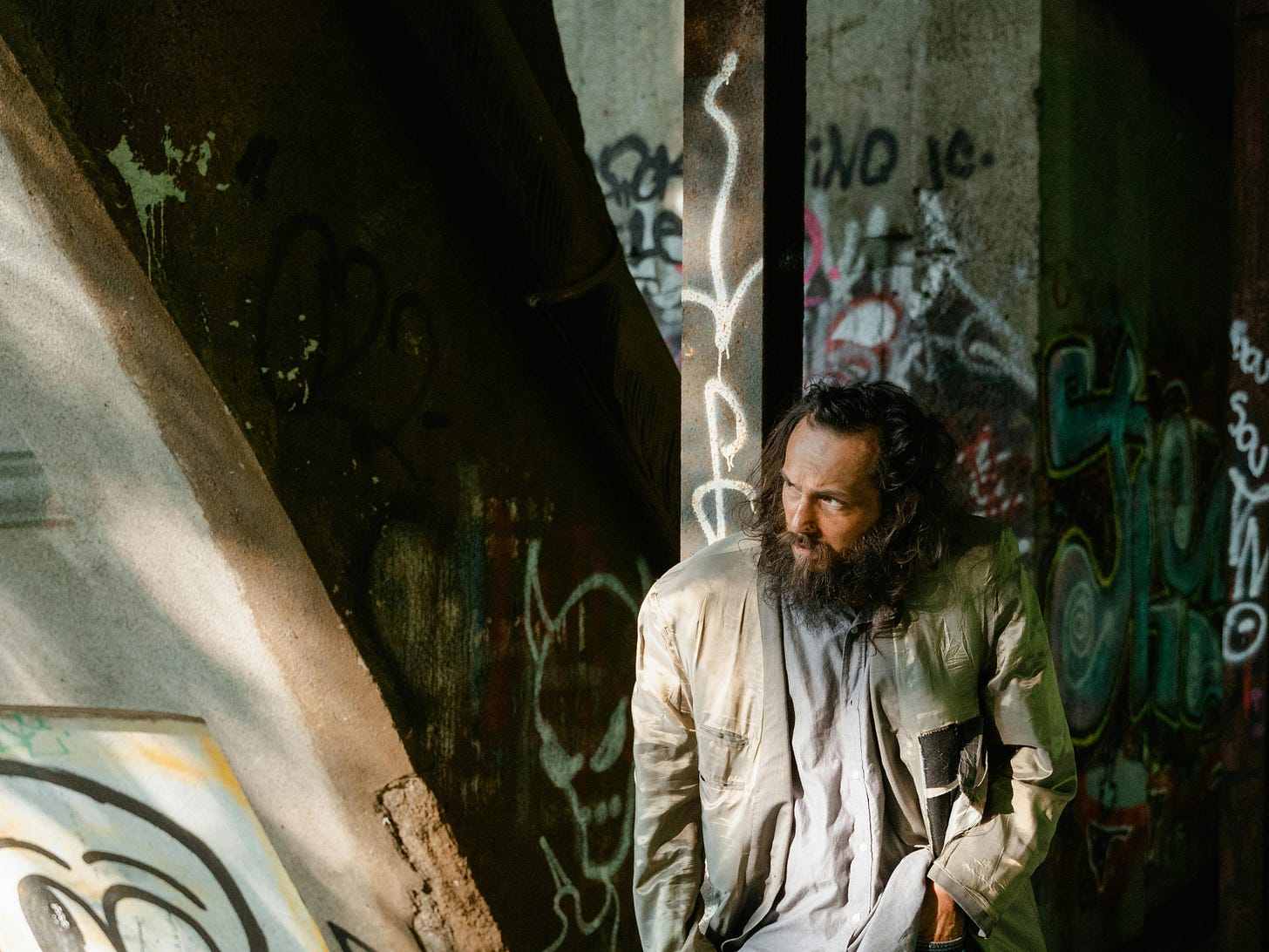 poor old man with beard surrounded by grafitti