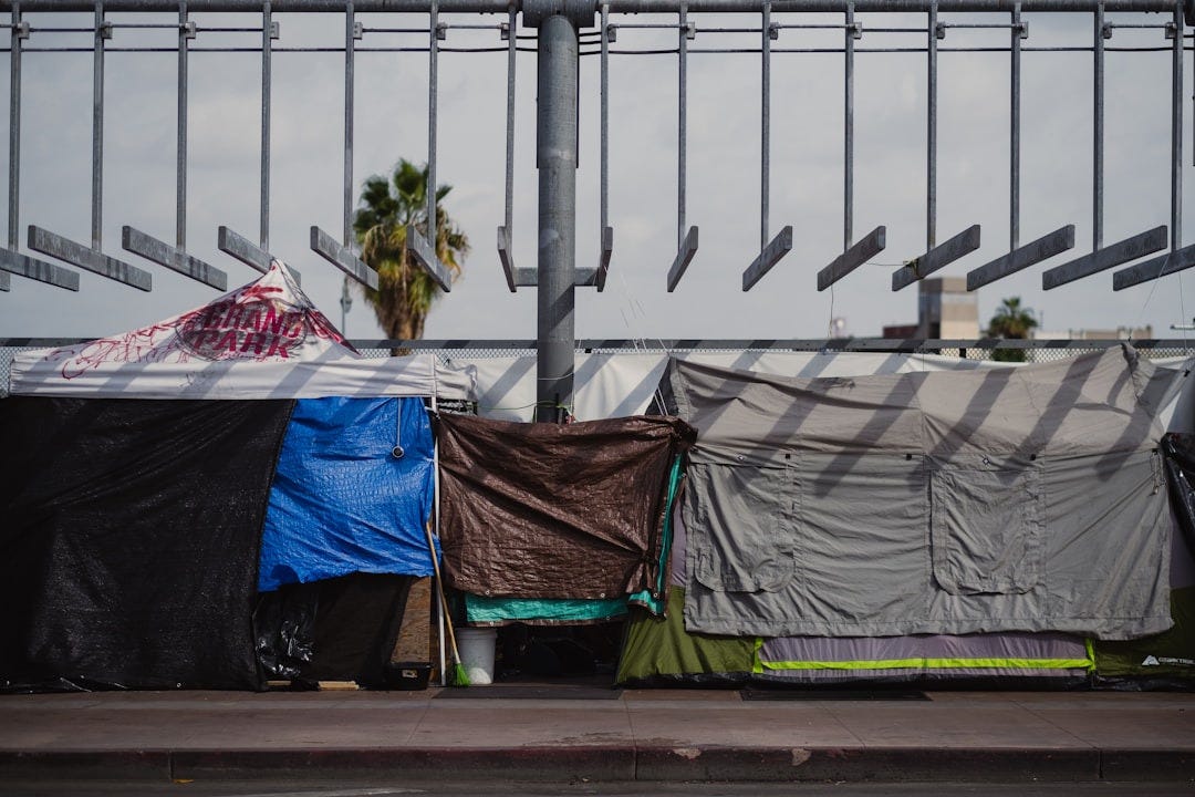 a group of tents sitting on top of a sidewalk a group of tents sitting on top of a sidewalk