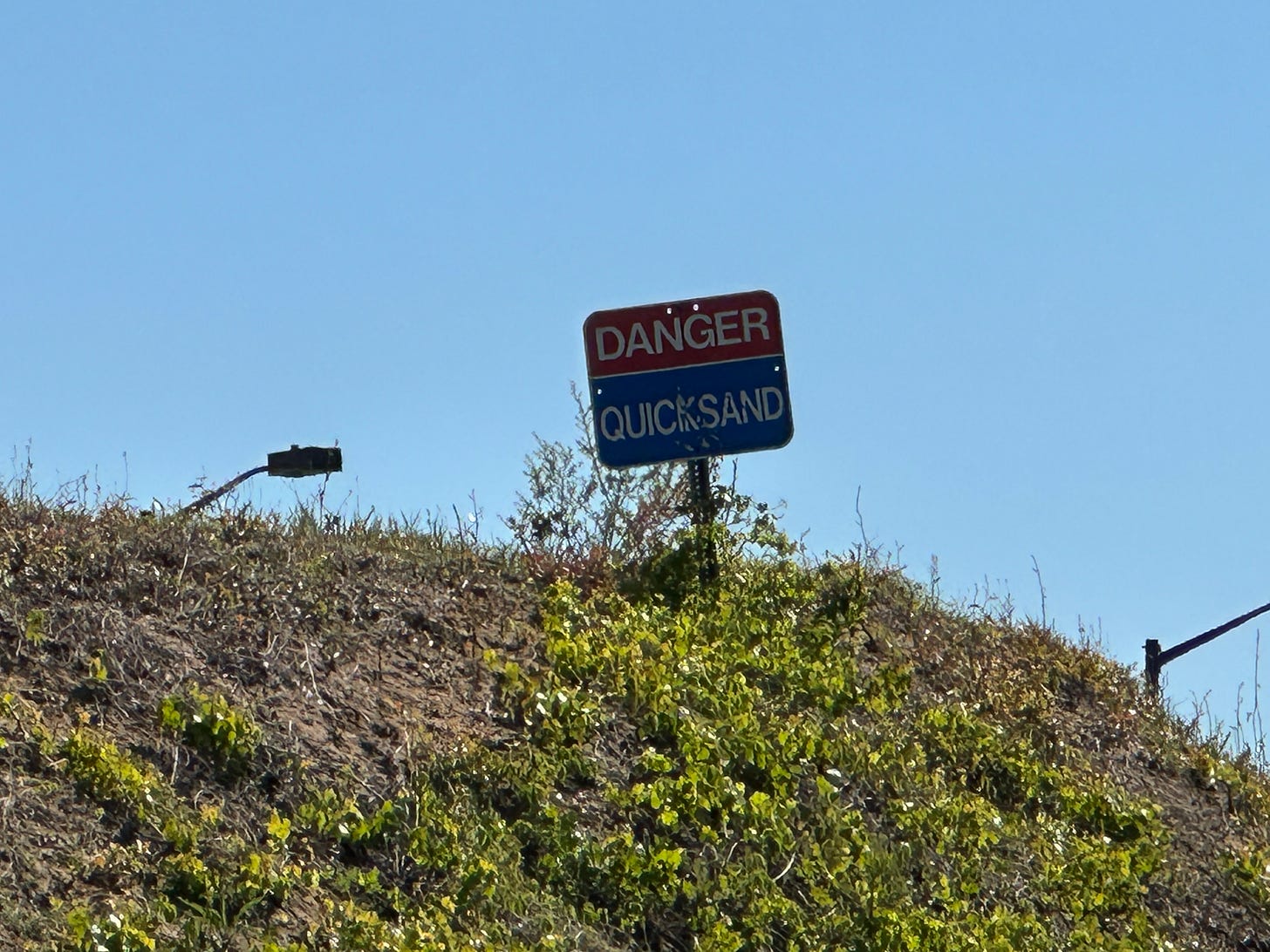 Sign that says "Danger: Quicksand" Sign that says "Danger: Quicksand"